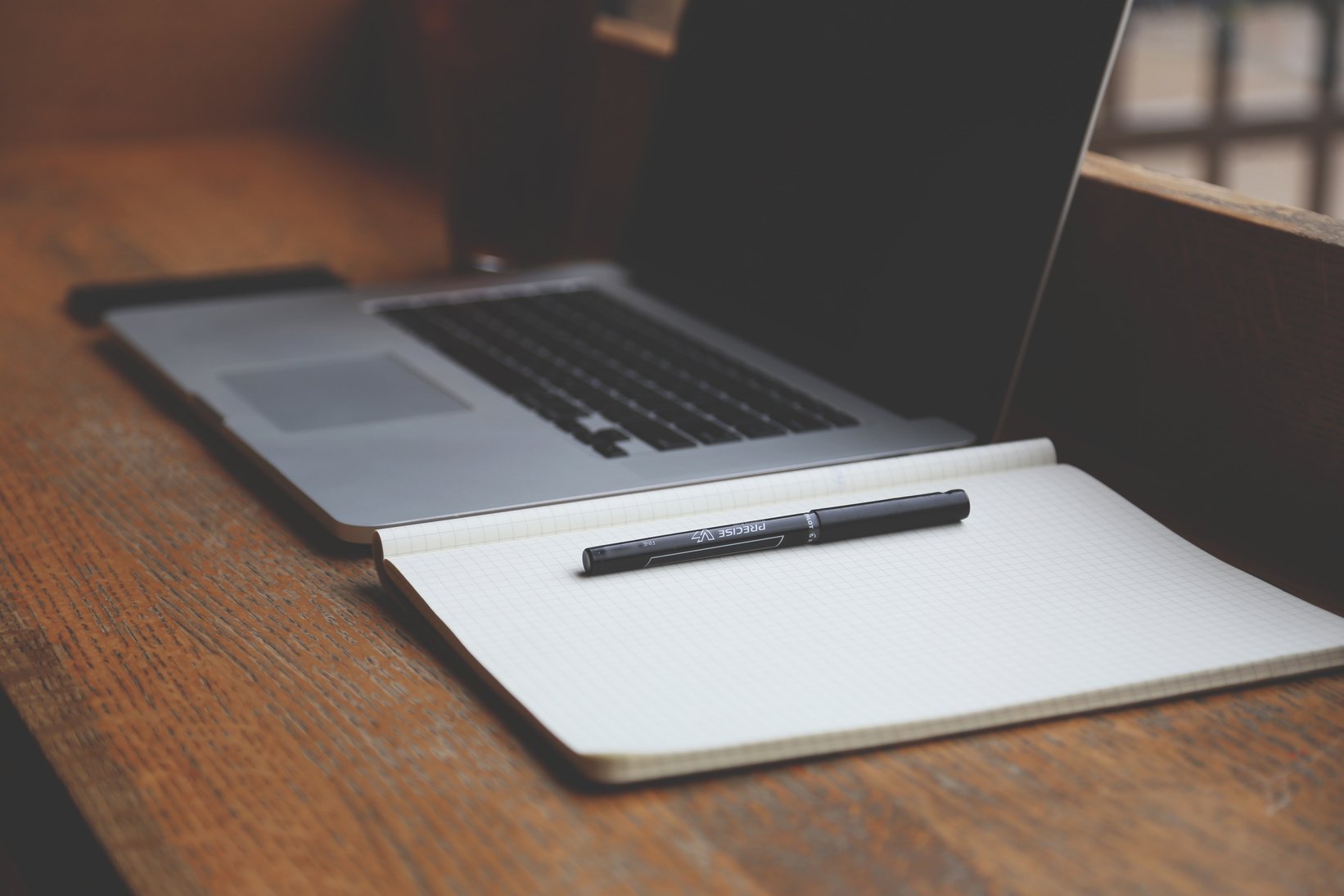 Macbook Pro Beside Book and Pen